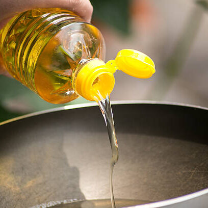 Pouring food oil in hot pan for deep frying.